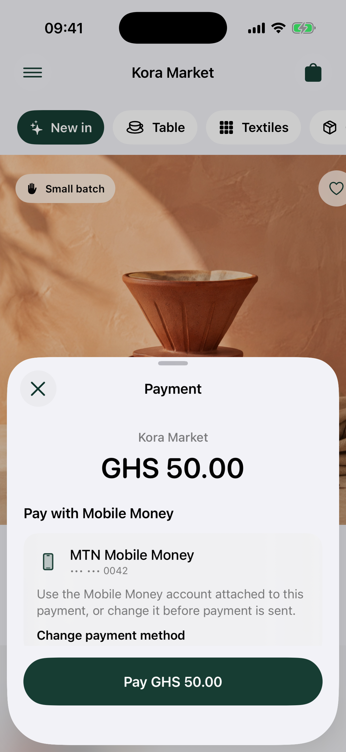 Native Inttegro payment sheet presented over the Kora Market demo, showing the merchant, amount, and attached mobile money account.